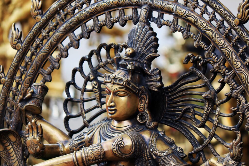 Close-up of a detailed bronze sculpture of a Hindu deity, showcasing intricate craftsmanship.
